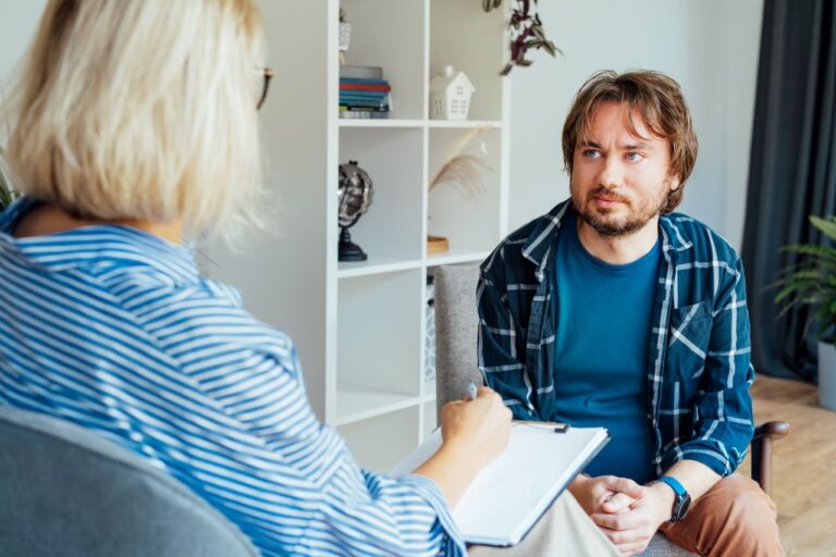 a therapist discussing the benefits of cranial sacral therapy to a patient