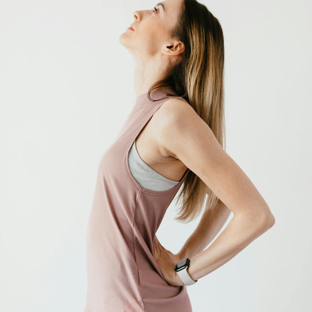 Woman using a massage ball to release lower back and hip tension, promoting relief through self-care and myofascial release.